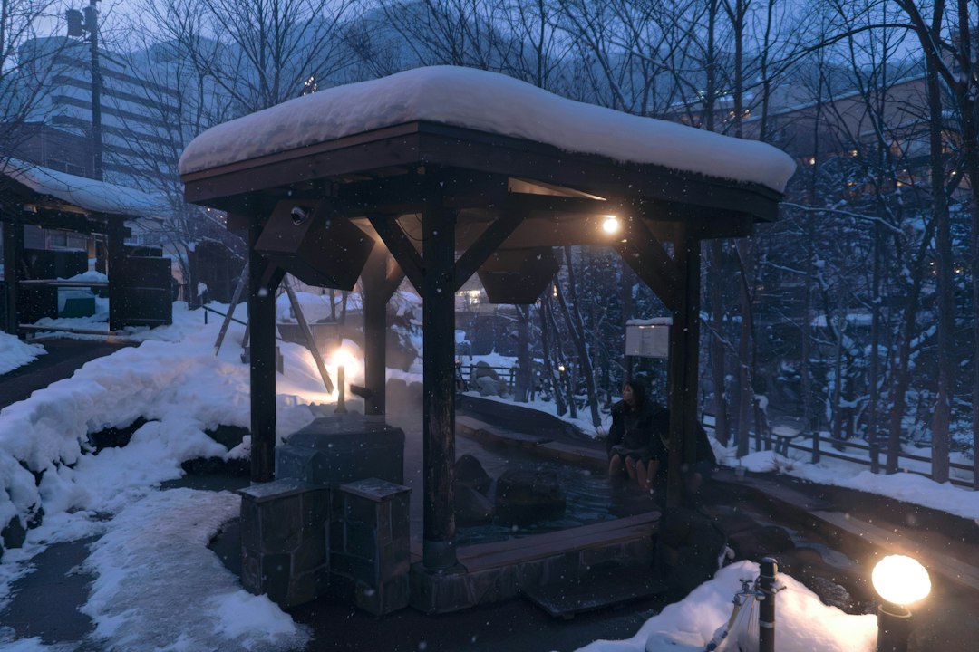Overdekt buitenbad van een onsen met sneeuw in de avond